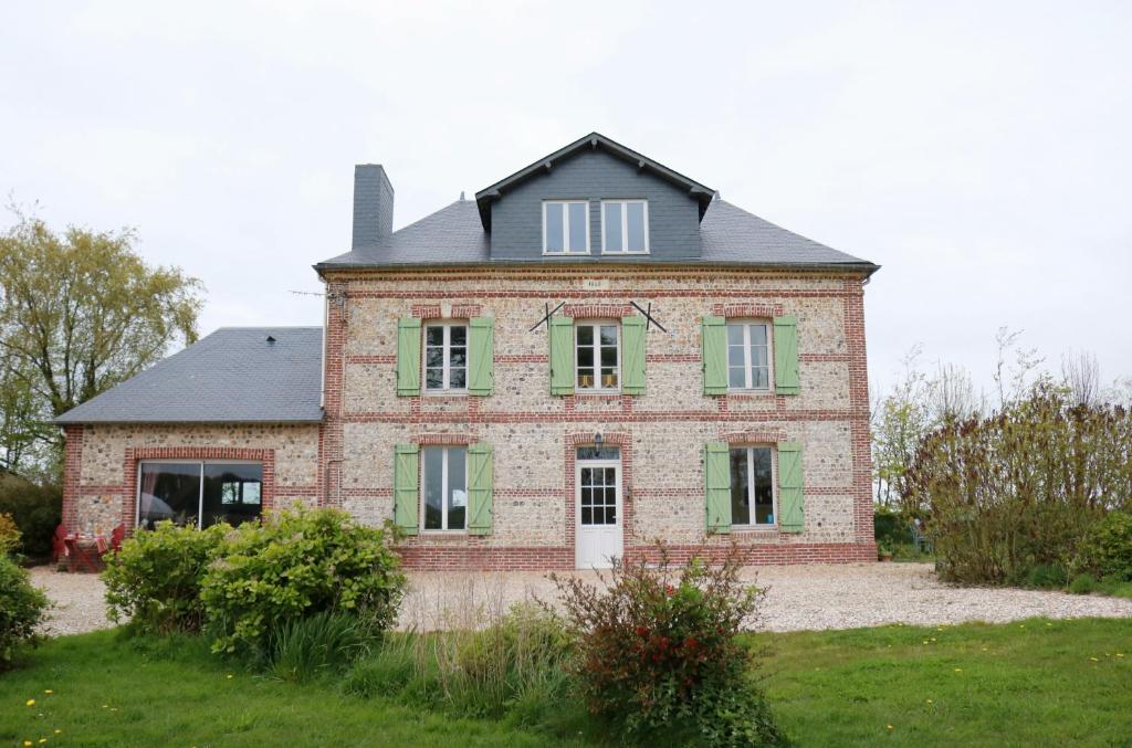 an old brick house with green shutters at Chambres d'Hôtes " Le Clos des Colimaçons " in Maniquerville