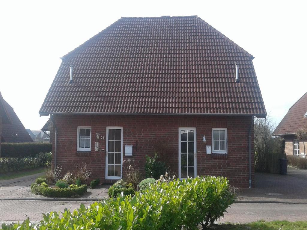 una casa de ladrillo rojo con techo negro en Ferienhaus Hooksiel, en Hooksiel