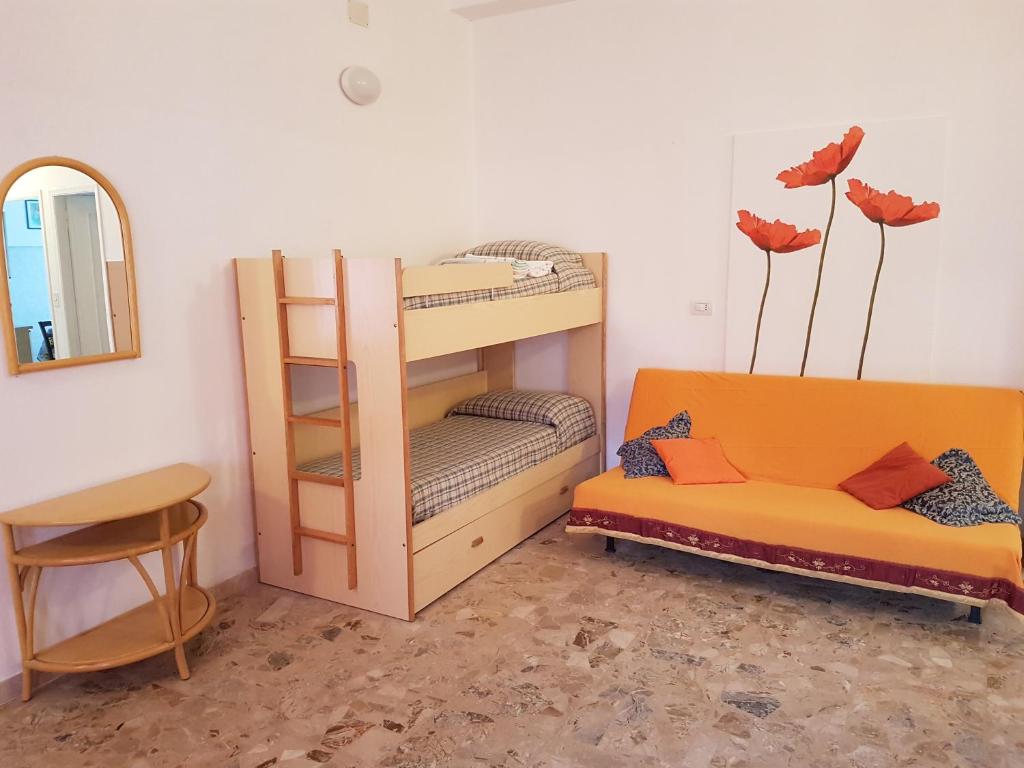 デイヴァ・マリーナにあるAppartamento Mare Mossoの二段ベッド、椅子、鏡が備わる客室です。