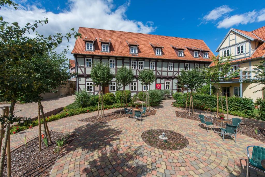 ein Gebäude mit einem Innenhof mit Stühlen und Bäumen in der Unterkunft Maria Aurora in Quedlinburg