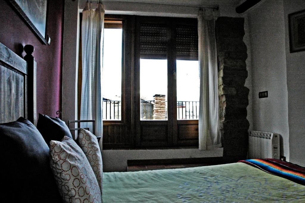 1 dormitorio con cama y ventana en Casa Lugaré, en Ayerbe