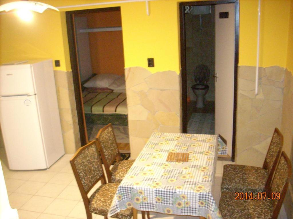 jadalnia ze stołem i krzesłami oraz sypialnia w obiekcie Kelemen Apartmanok w Abádszalók