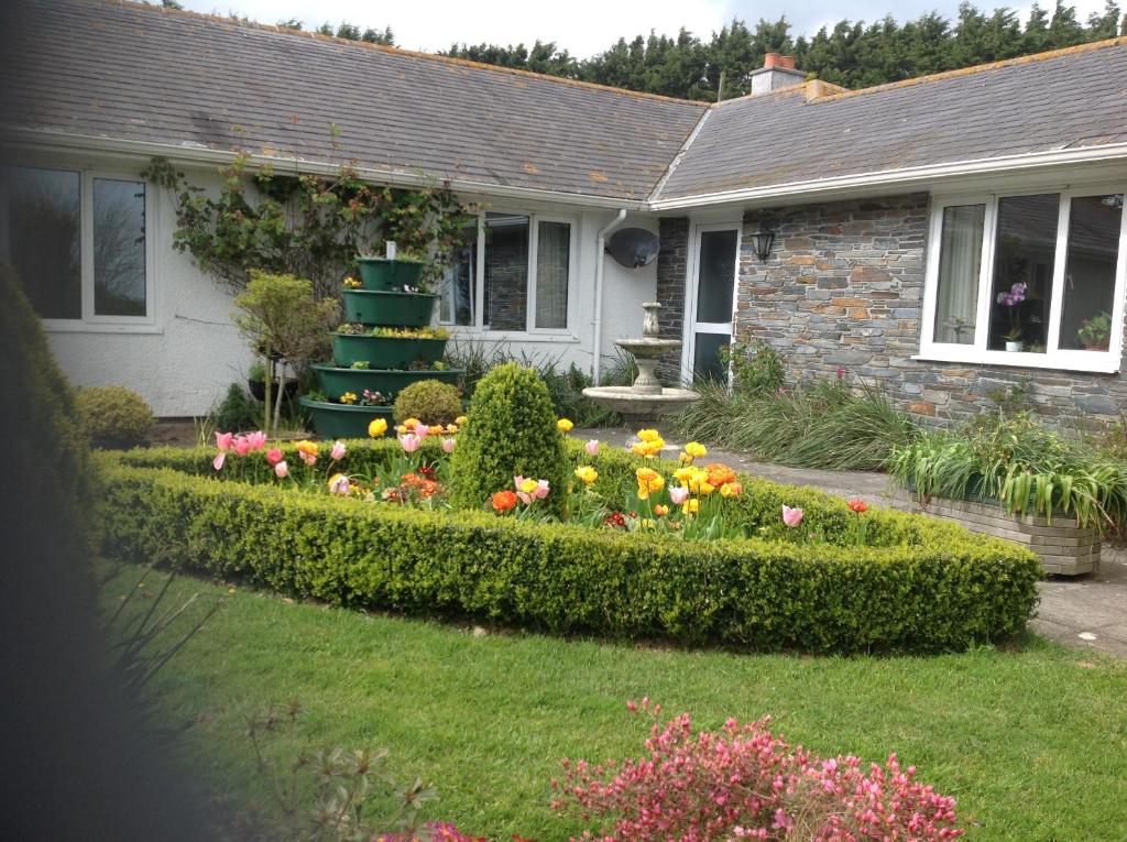 a house with a garden with flowers and a cake at Estuary View Farm in Kingsbridge