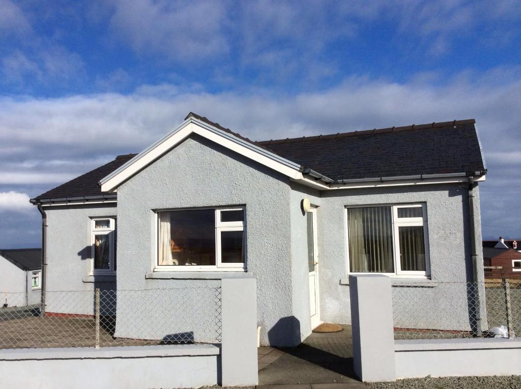 a small white house with a black roof at The Homer in Kilmuir