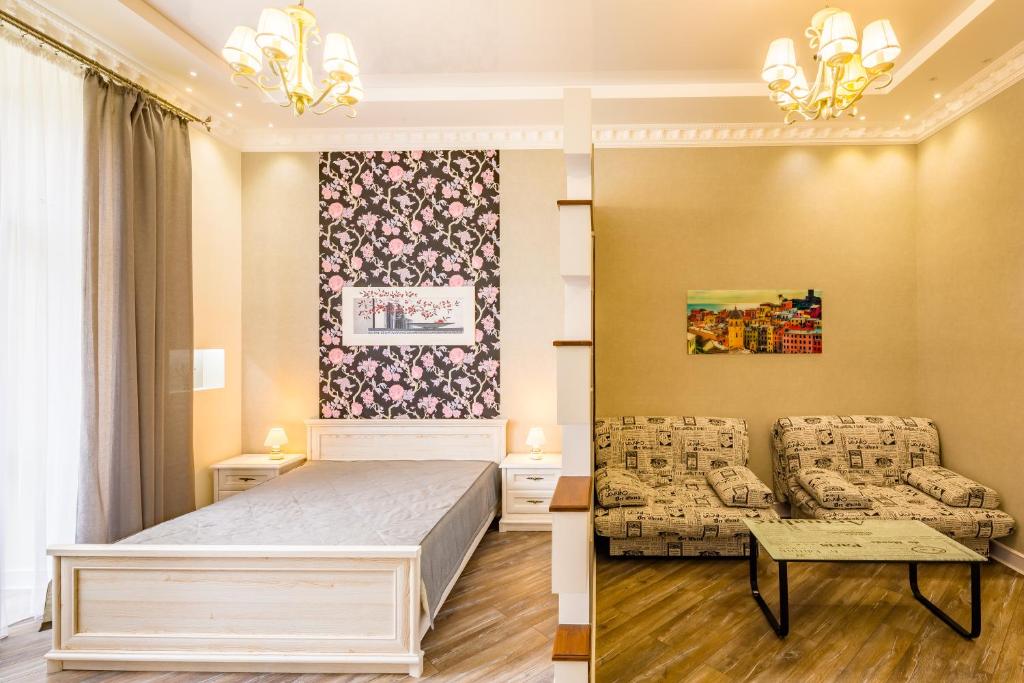 ein Schlafzimmer mit einem Bett, einem Sofa und einem Tisch in der Unterkunft VIP Apartments in Lwiw