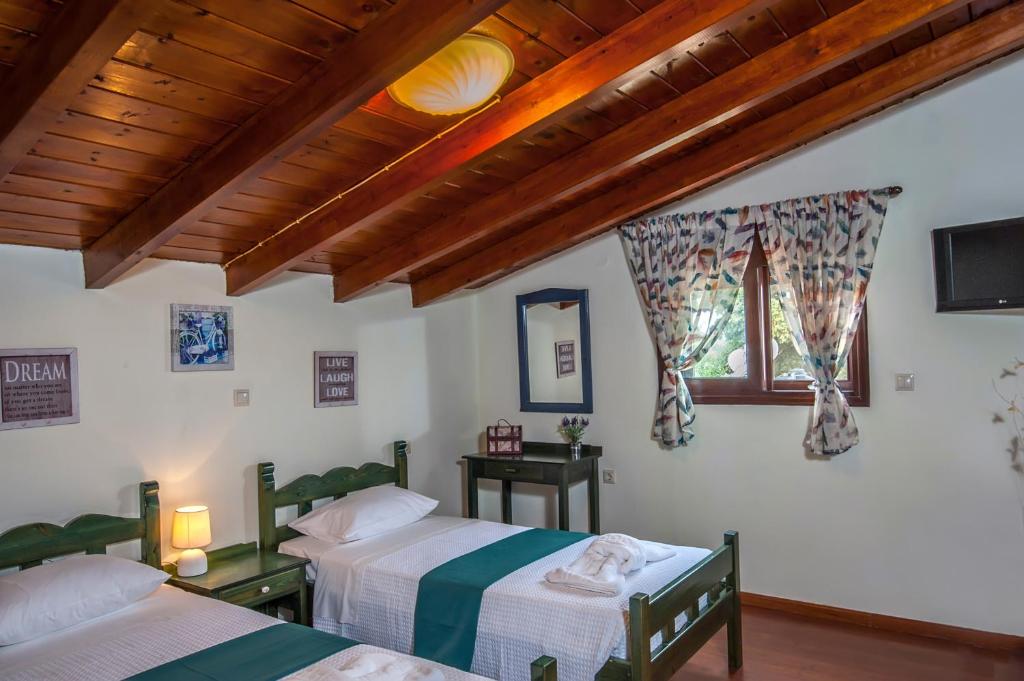 sypialnia z dwoma łóżkami i oknem w obiekcie Kyriaki's Cozy Apartments w mieście Agia Marina Nea Kydonias