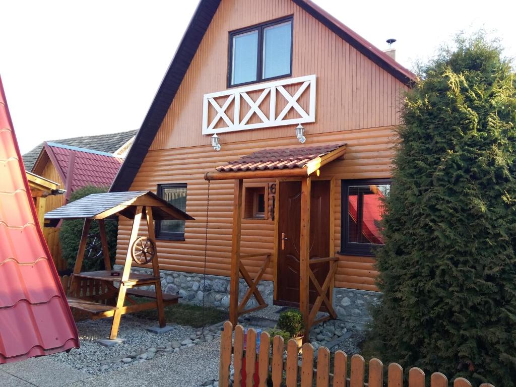a wooden house with a fence and a swing at Chata Talia in Liptovský Mikuláš