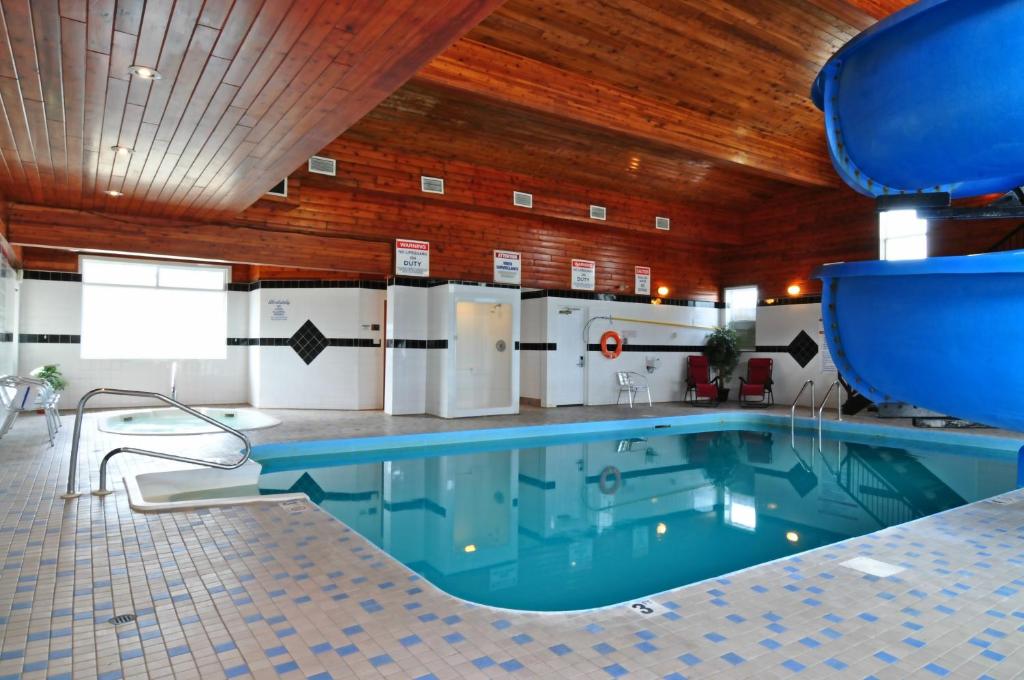 a large swimming pool in a building with a wooden ceiling at Travelodge by Wyndham Golden Sportsman Lodge in Golden