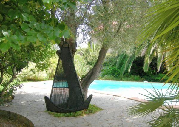 een hangmat hangend aan een boom naast een zwembad bij Campagne Beausoleil in La Seyne-sur-Mer