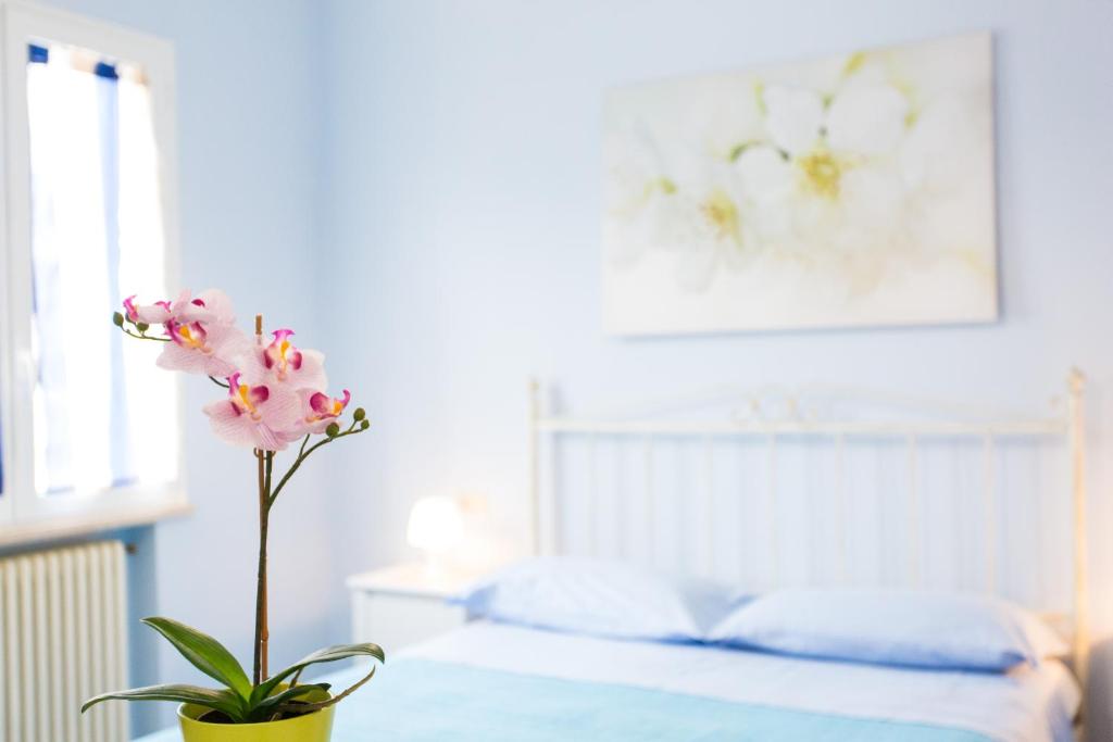 eine Vase mit einer Blume auf einem Tisch im Schlafzimmer in der Unterkunft Residence Kimba in Rimini