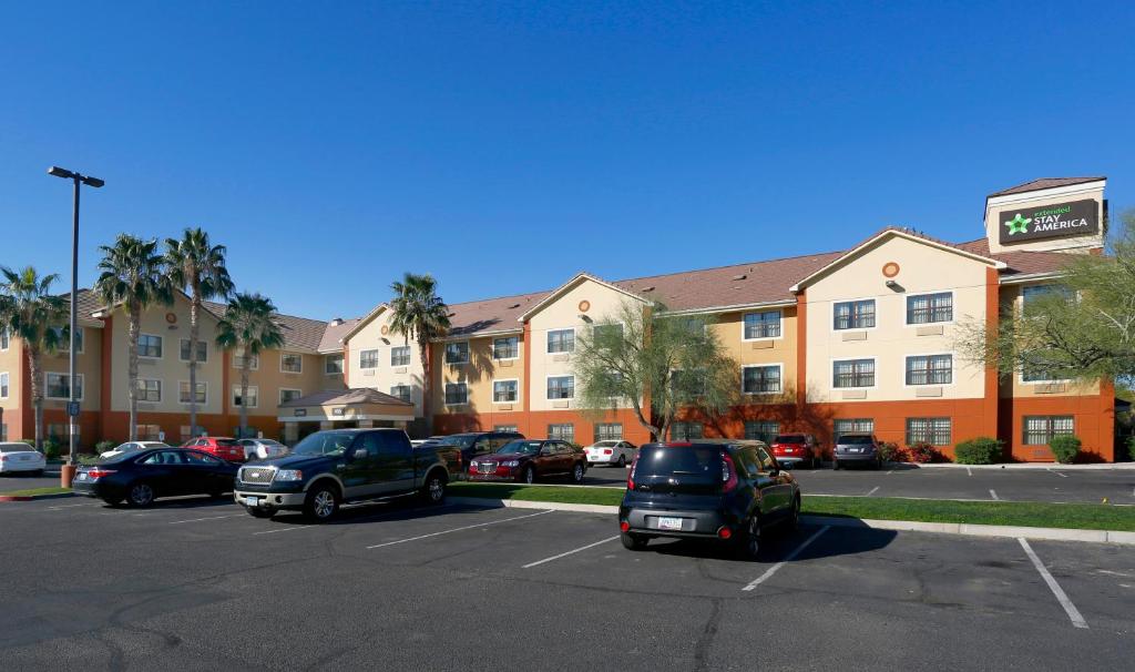 un estacionamiento con coches estacionados frente a un hotel en Extended Stay America Suites - Phoenix - Mesa en Mesa