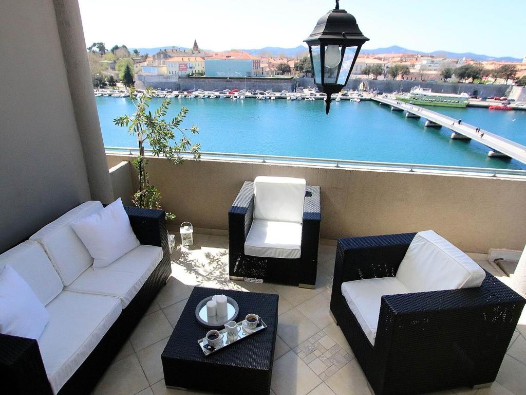 a balcony with couches and a view of a harbor at The View in Zadar