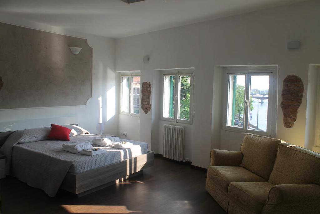 een woonkamer met een bed, een bank en ramen bij Residenza San Tomaso in Verona