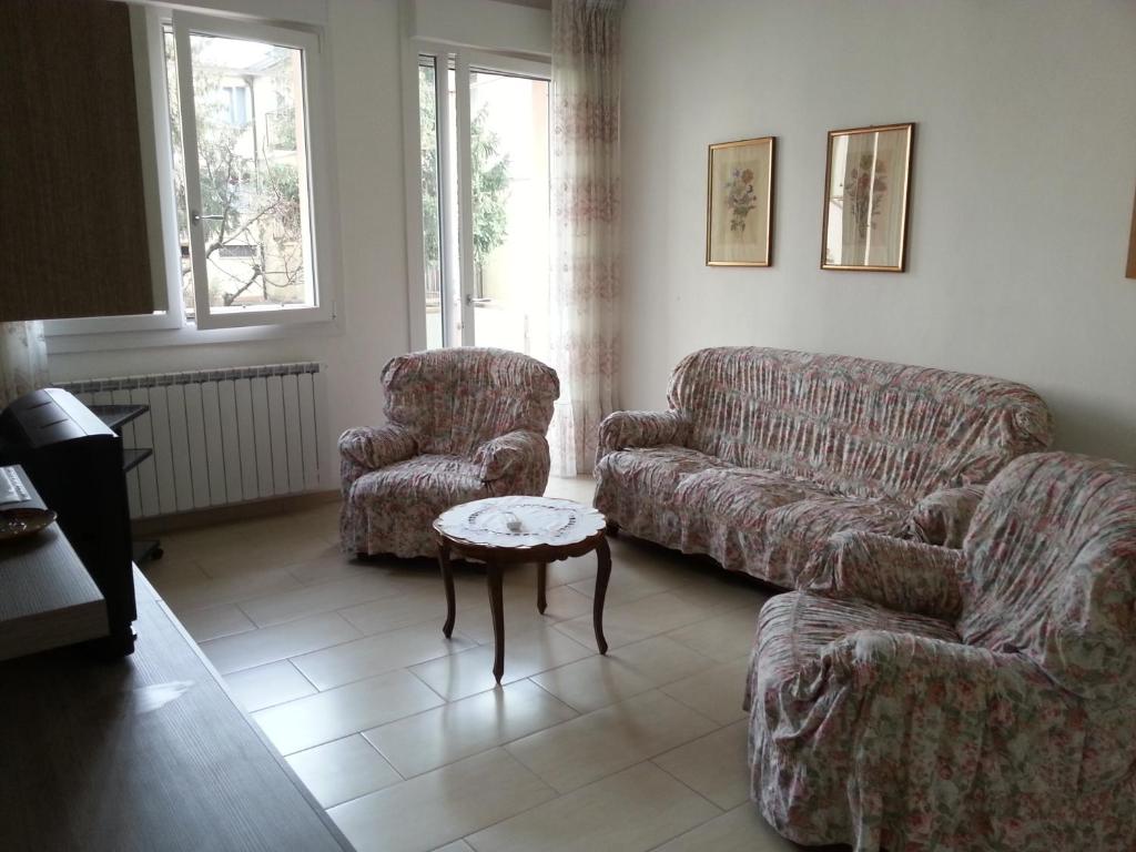 uma sala de estar com um sofá e uma cadeira em San Teodoro Apartment em Mestre
