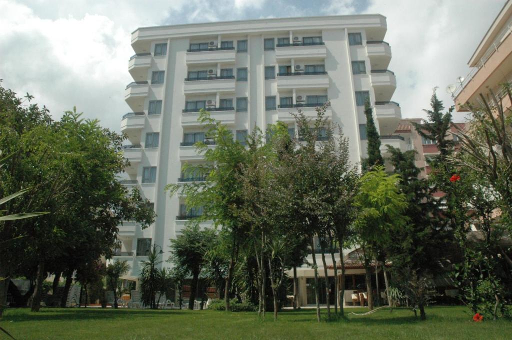 a white building with trees in front of it at Suite Laguna Otel in Antalya