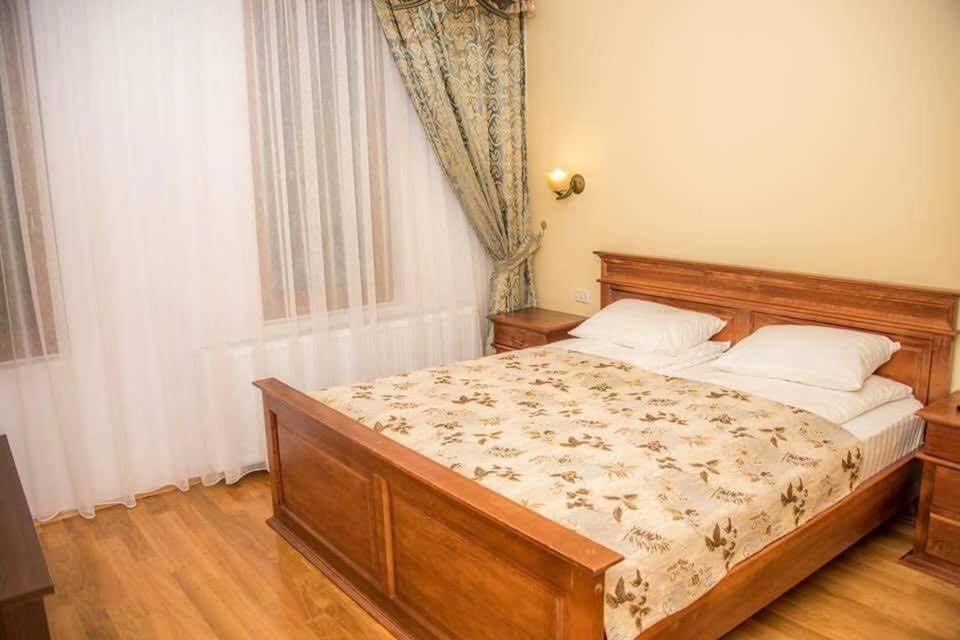 a bedroom with a bed with a wooden headboard at Pensiunea Maria in Fîrdea