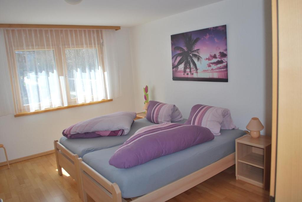 a bedroom with a bed with purple pillows on it at Aquarell Apartments in Saas-Grund