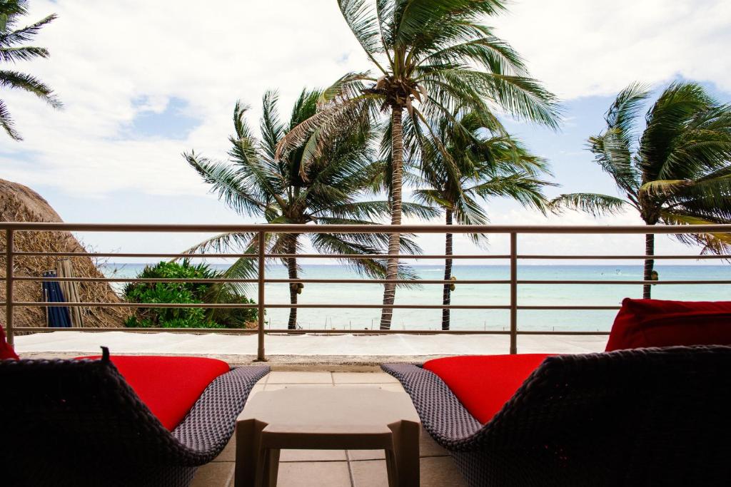 a view of the ocean from a balcony with palm trees at Ocean Front Corto Maltes 104 in Downtown in Playa del Carmen