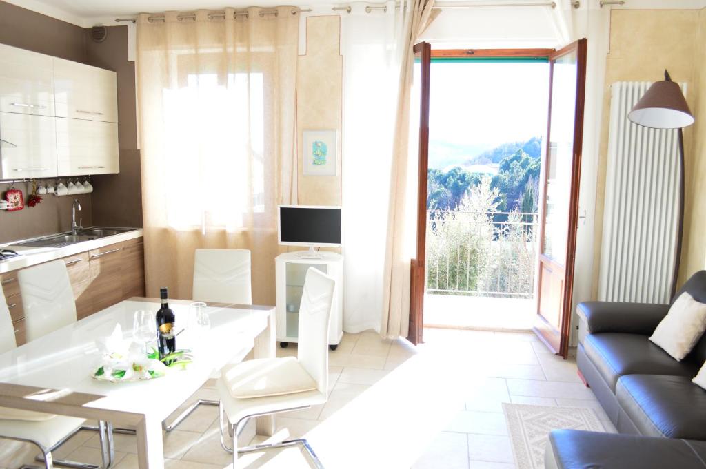 a kitchen and living room with a white table and chairs at Apartment with Beautiful Sun in Montepulciano