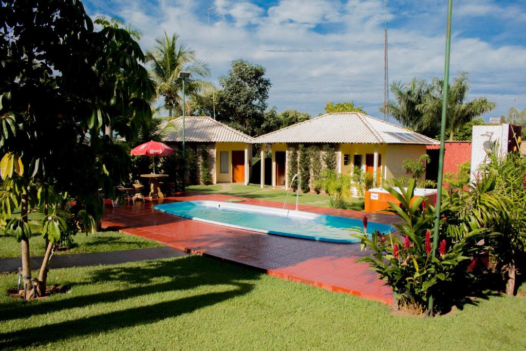 a villa with a swimming pool in front of a house at Pousada Recanto Do Sussego in Olímpia