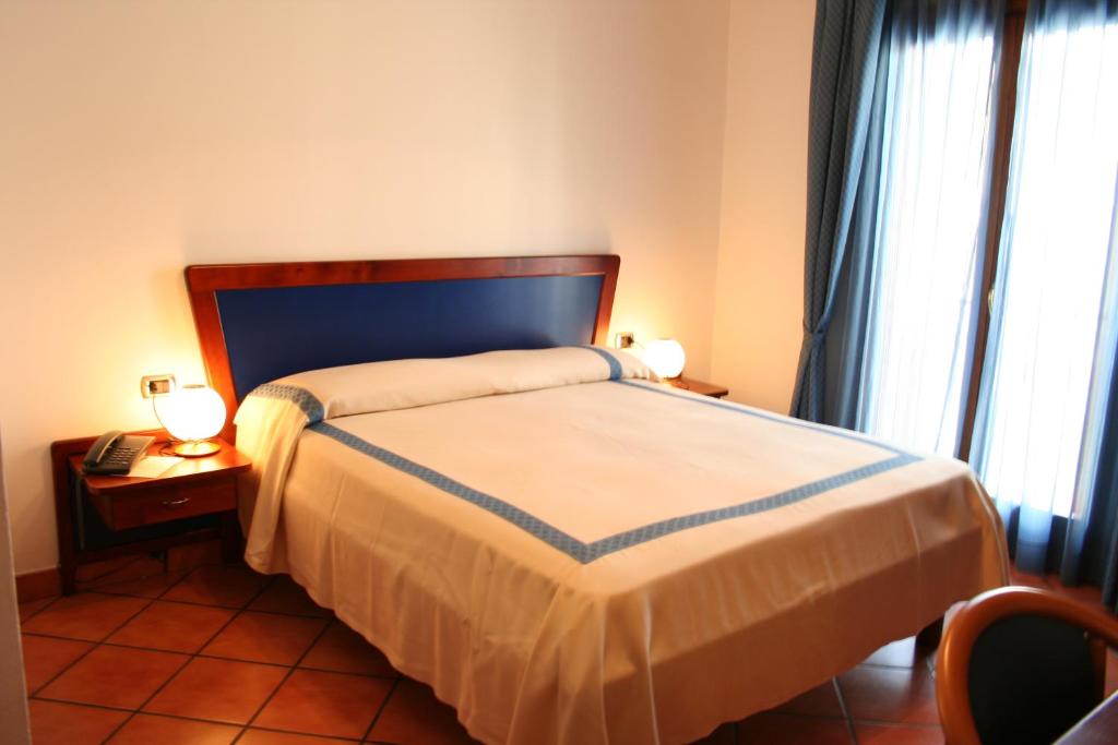 Postel nebo postele na pokoji v ubytování Hotel Locanda dei Trecento