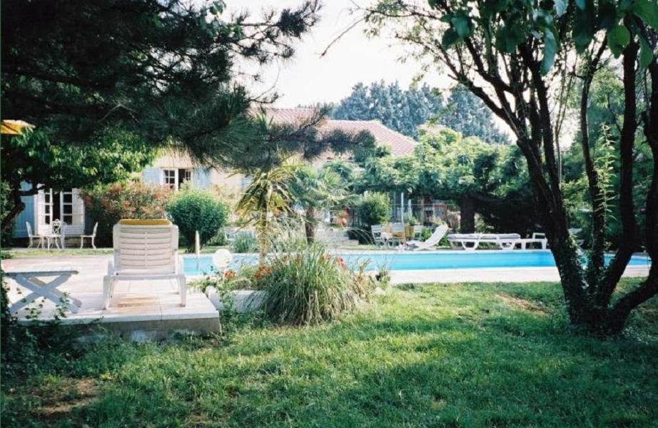 a house with a pool and a chair in a yard at Chambres d'Hôtes Saint Vérédème in Pujaut