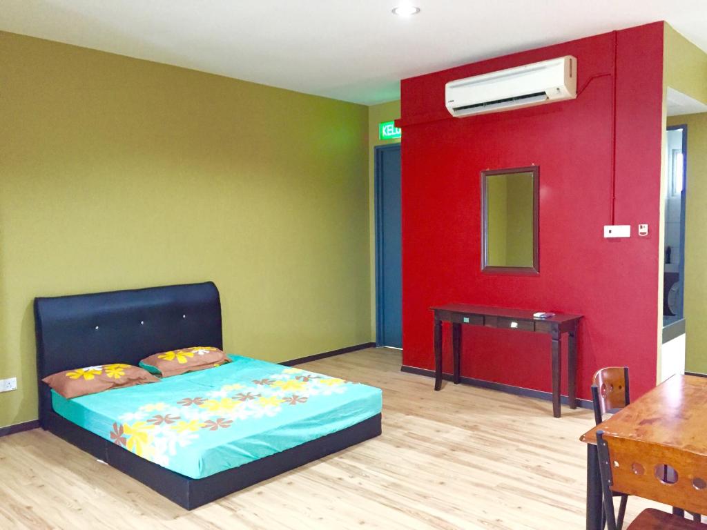 a bedroom with a bed and a red wall at SS Homestay Borneo Housing SL4 in Kampung Nombor Dua