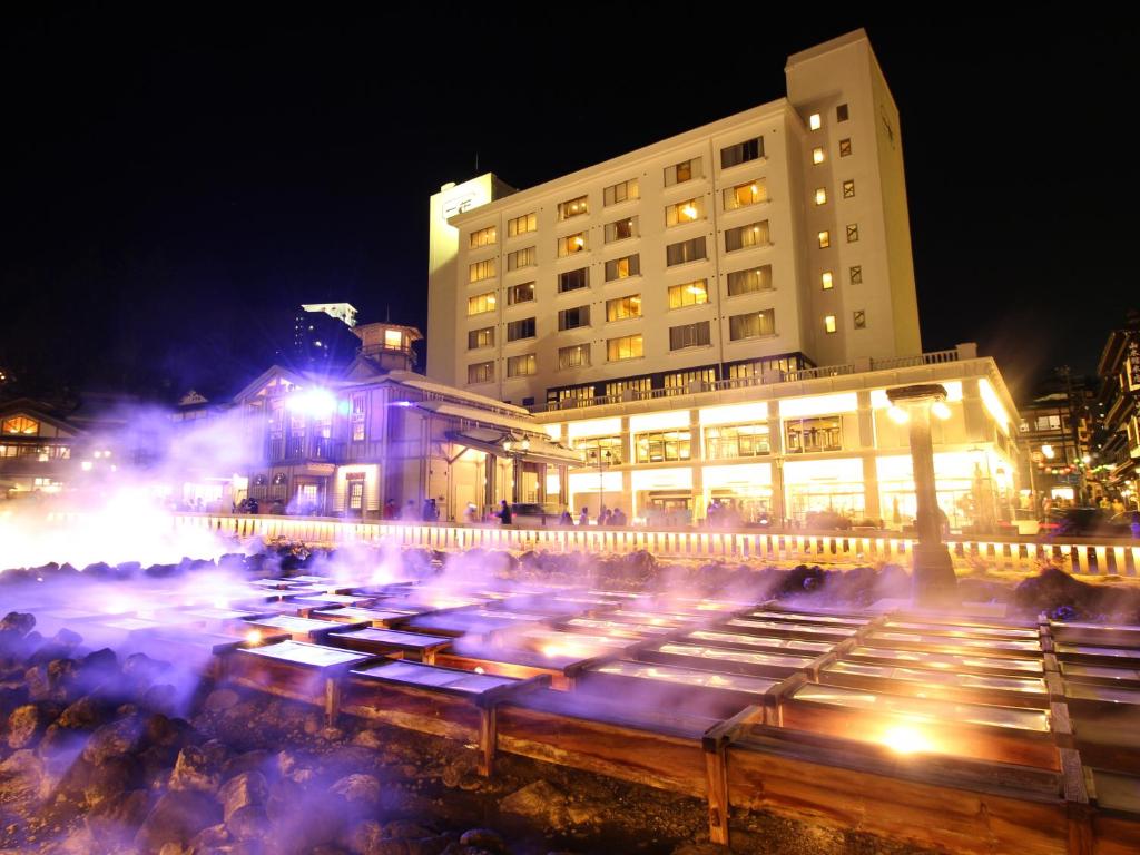 una città di notte con un edificio e luci di Hotel Ichii a Kusatsu