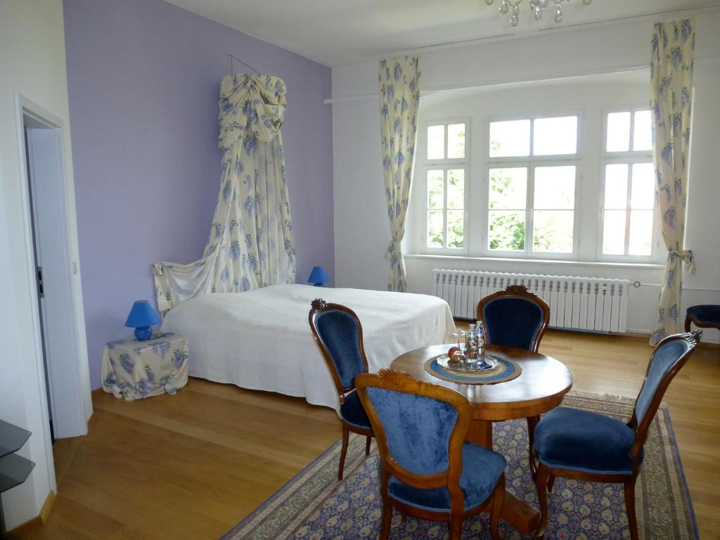 Schlafzimmer mit einem Bett, einem Tisch und Stühlen in der Unterkunft Schloss Hotel Wallhausen in Wallhausen