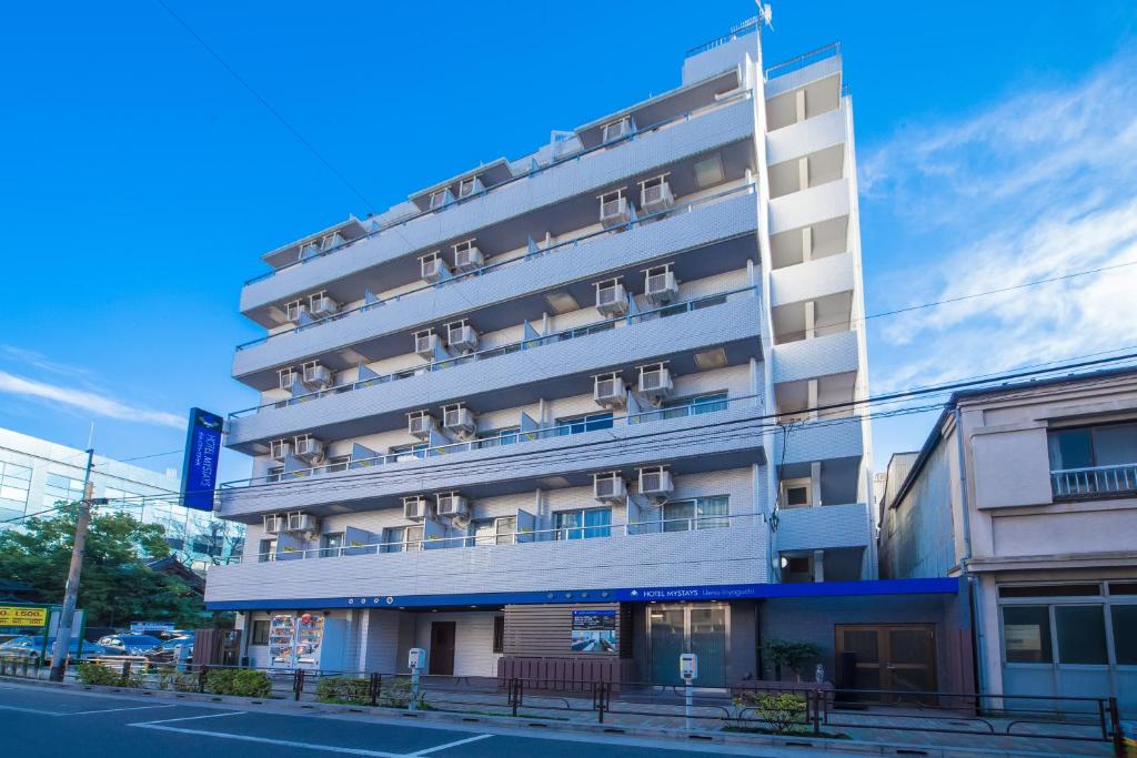 a tall white building on the side of a street at HOTEL MYSTAYS Ueno Iriyaguchi in Tokyo