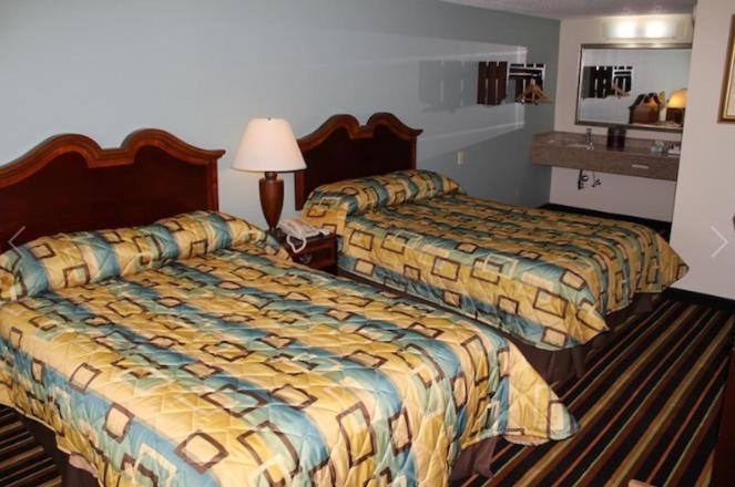 una habitación de hotel con 2 camas y una lámpara en Somatel Goodlettsville, en Goodlettsville