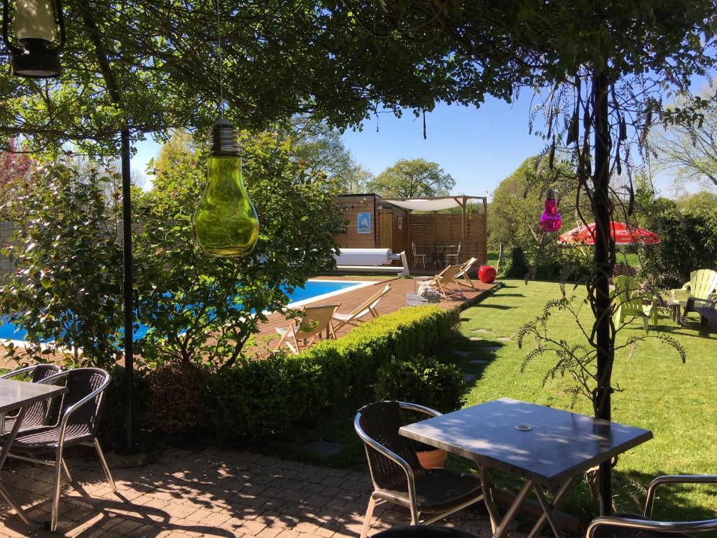 une cour avec une table et des chaises ainsi qu'une piscine dans l'établissement La maison du Lac, à Éguzon-Chantôme