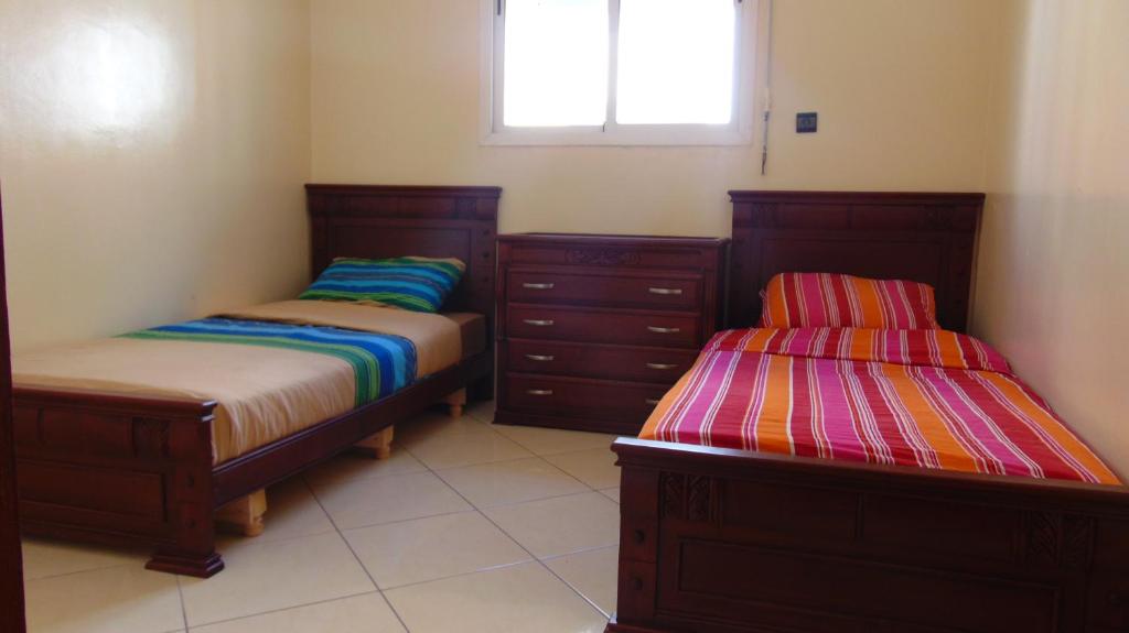 - une chambre avec 2 lits et une fenêtre dans l'établissement Suite Apartment Fawzi, à Agadir