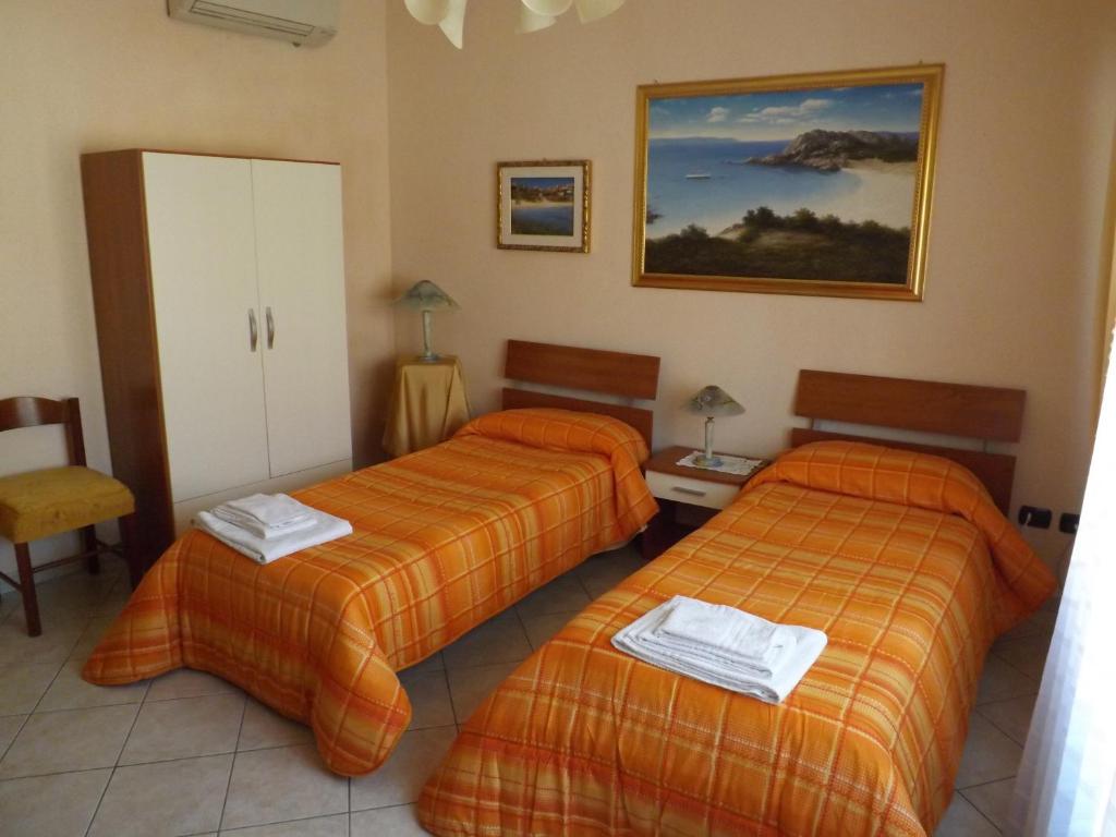 a hotel room with two beds with orange sheets at B&B Le Grazie in Siniscola