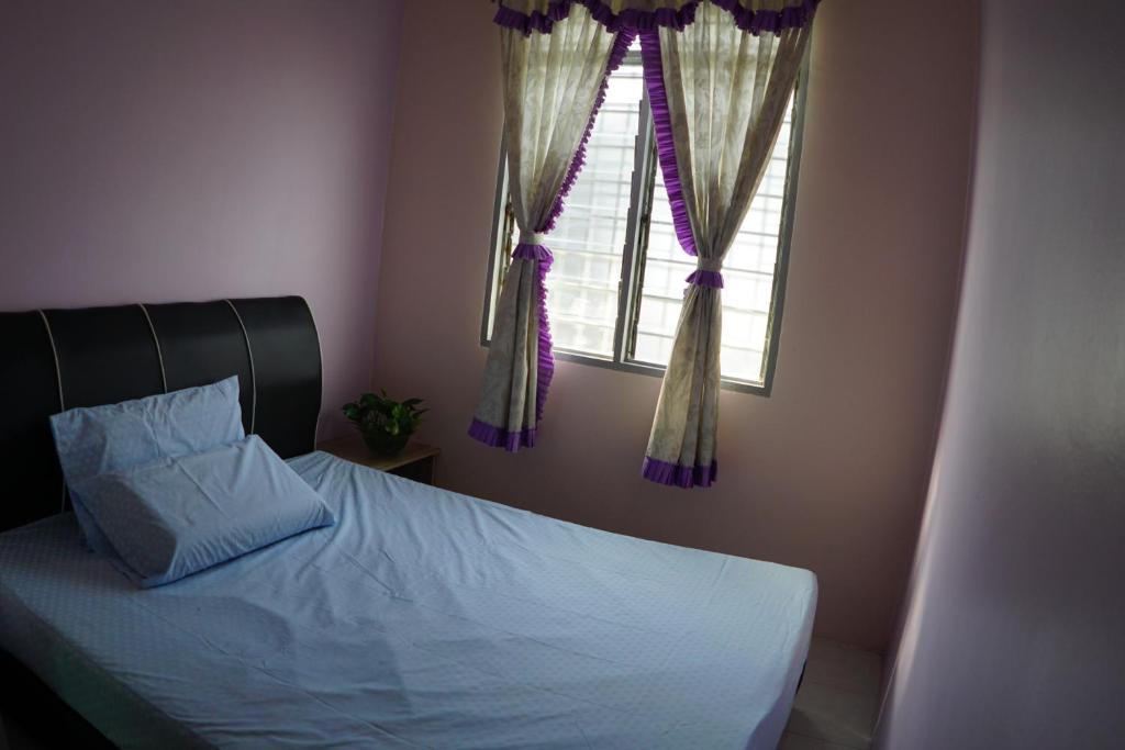 - une chambre avec un lit et une fenêtre avec des rideaux dans l'établissement Taiping Cozy Homestay, à Taiping