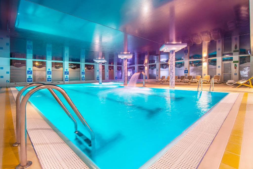 un hombre en una piscina en un edificio en Hotel Masuria en Łukta