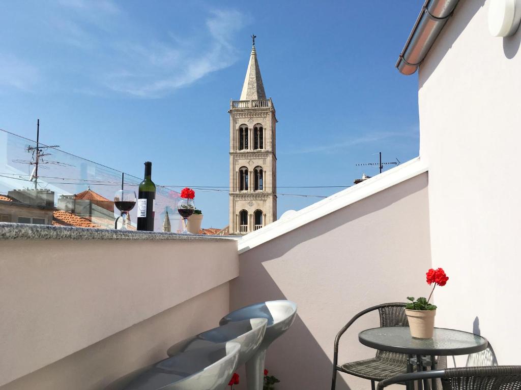 a balcony with a table and chairs and a church at Top Center Zadar Studio Apartments in Zadar