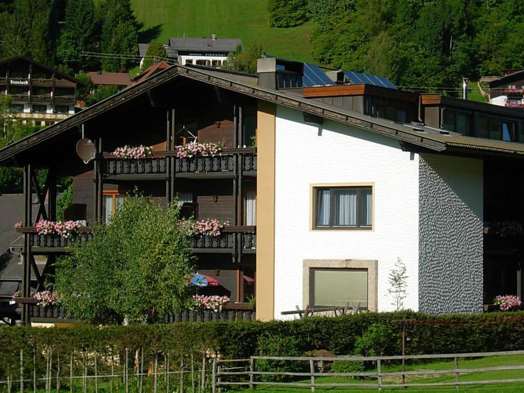 a white house with a balcony with flowers on it at Haus Nadja in Bad Kleinkirchheim