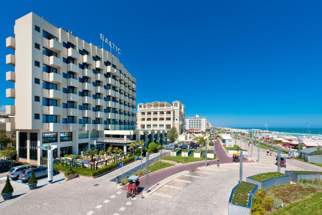 widok na ulicę z budynkiem i plażę w obiekcie Hotel Baltic Riccione-Fronte Mare w mieście Riccione