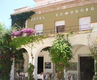 a hotel with flowers on the side of a building at Hotel Comodoro in Portbou