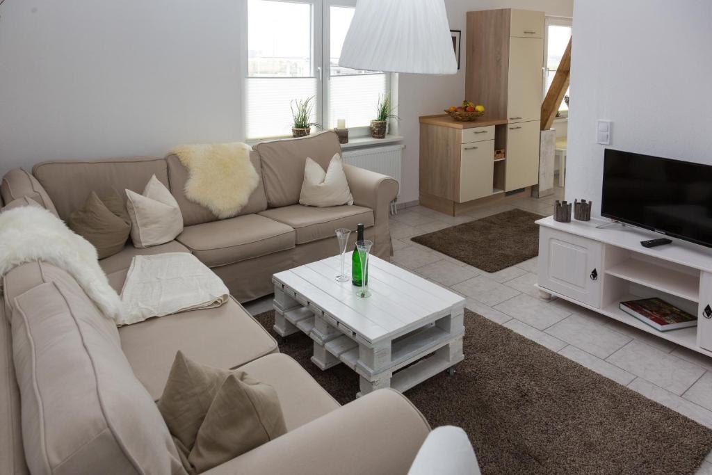 ein Wohnzimmer mit einem Sofa und einem TV in der Unterkunft Reiterhof an der Nordsee in Witzwort