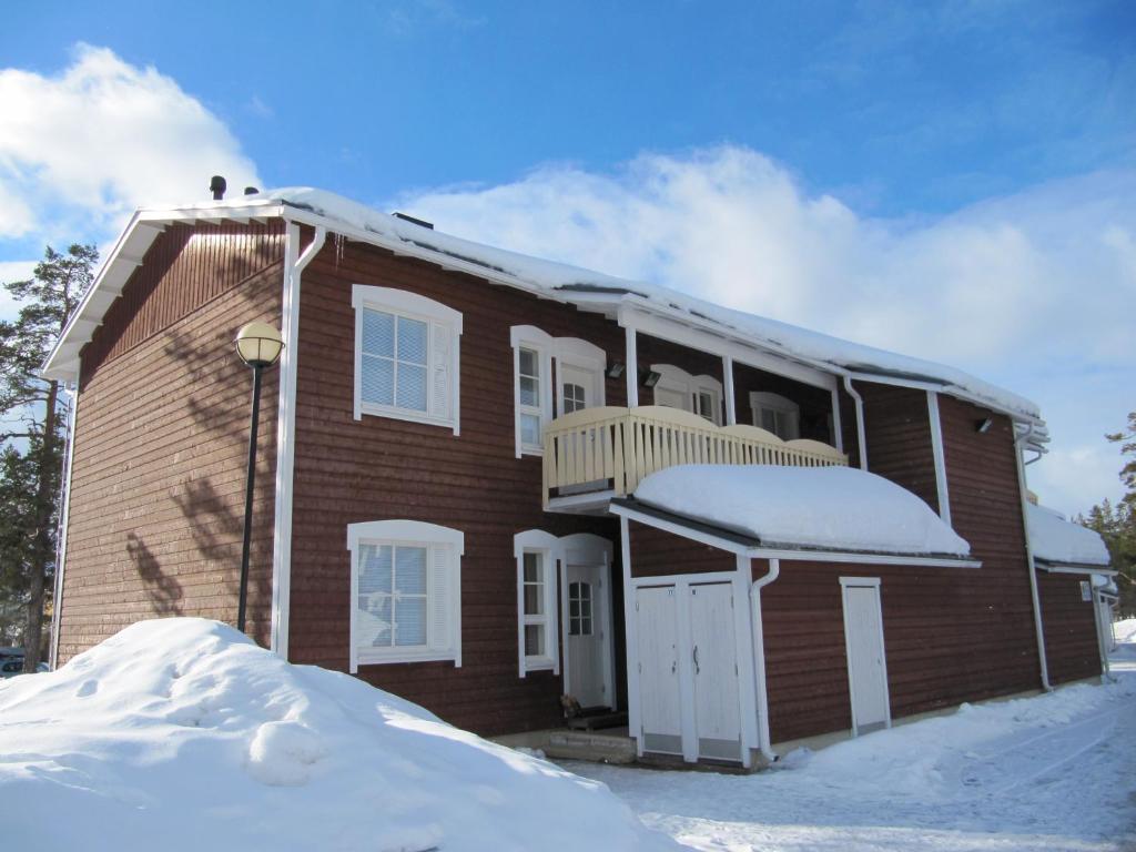 een stenen huis met sneeuw ervoor bij Lapin Kutsu Holiday Homes in Saariselkä