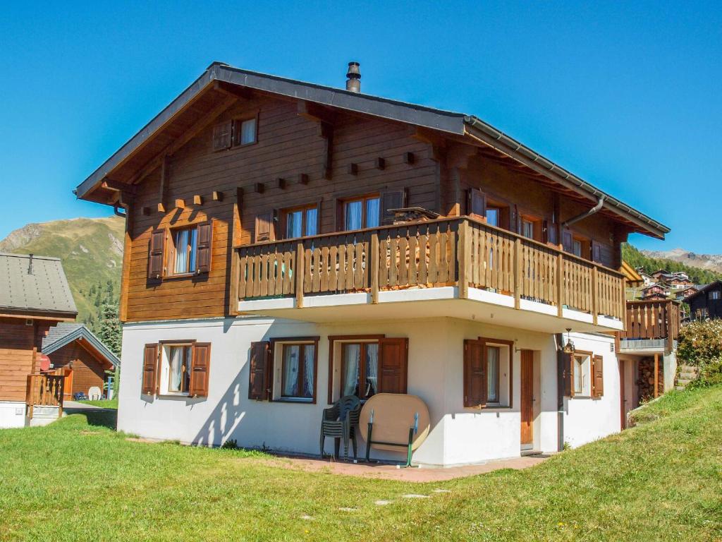 ein großes Holzhaus mit Balkon auf einem Hügel in der Unterkunft Chalet Silberdistel in Rosswald