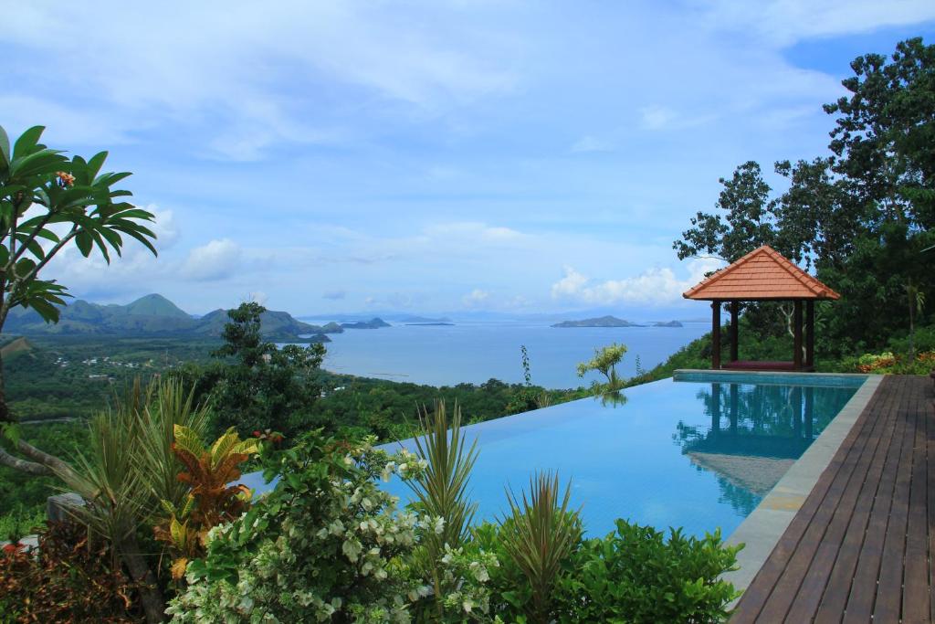 a swimming pool with a view of the ocean at Villa Domanik in Labuan Bajo