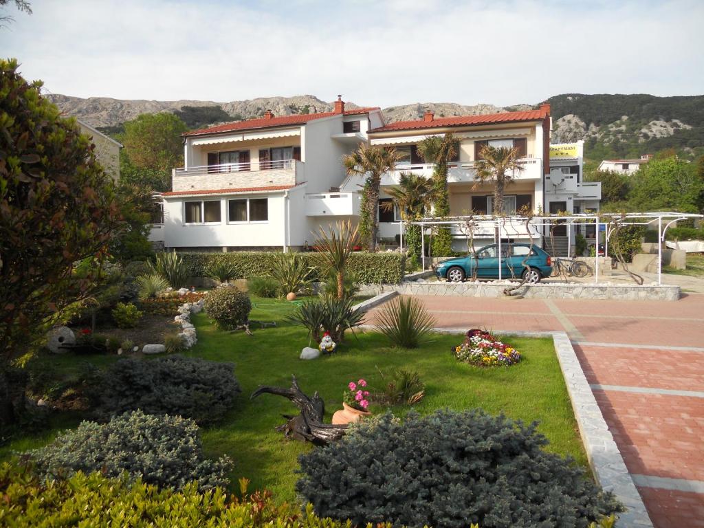 a house with a garden in front of it at Apartments Mihalić in Baška
