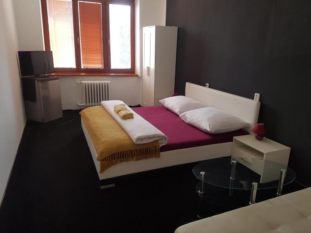 ロジュノフ・ポト・ラドホシュチェムにあるhotel KORUNAのベッドルーム1室(紫色のマットレスを使用した大型ベッド1台付)