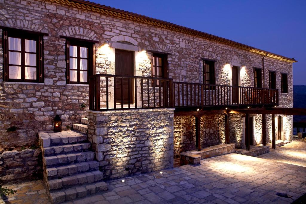 une maison en pierre avec un escalier et un balcon. dans l'établissement Ilakia, à Tholón