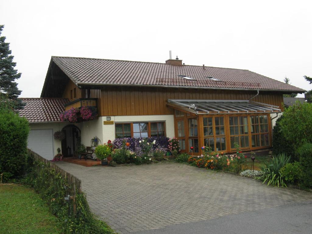 ein Haus mit vielen Blumen davor in der Unterkunft Ferienwohnungen Weigl in Bad Birnbach