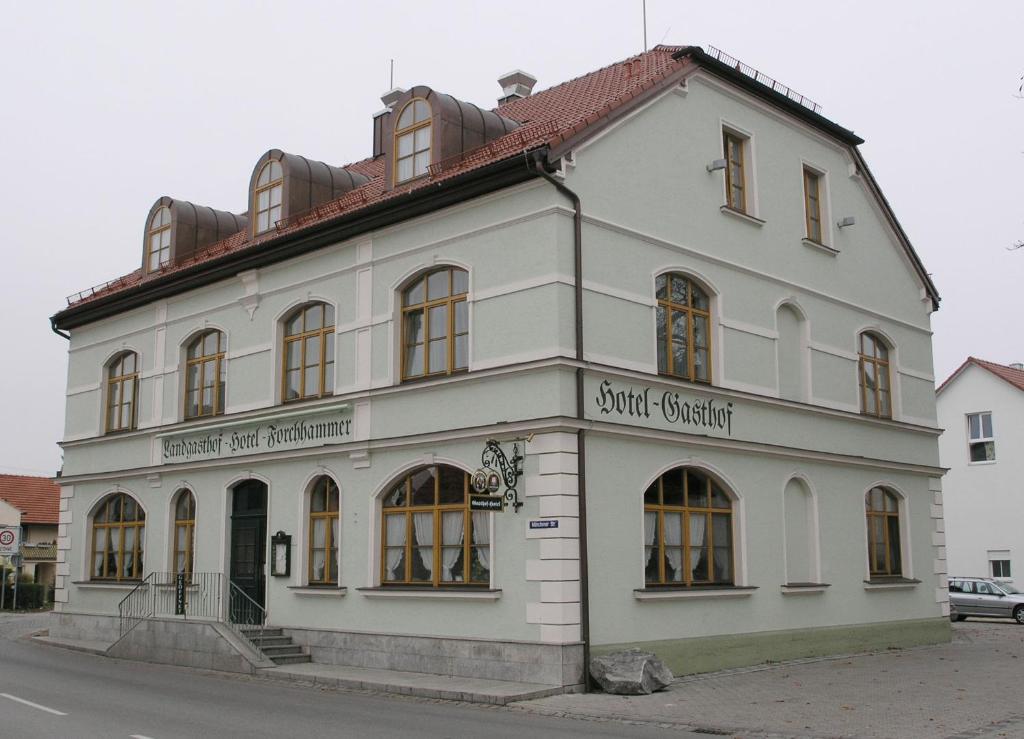 a white building on the side of a street at Landgasthof und Hotel Forchhammer in Pliening