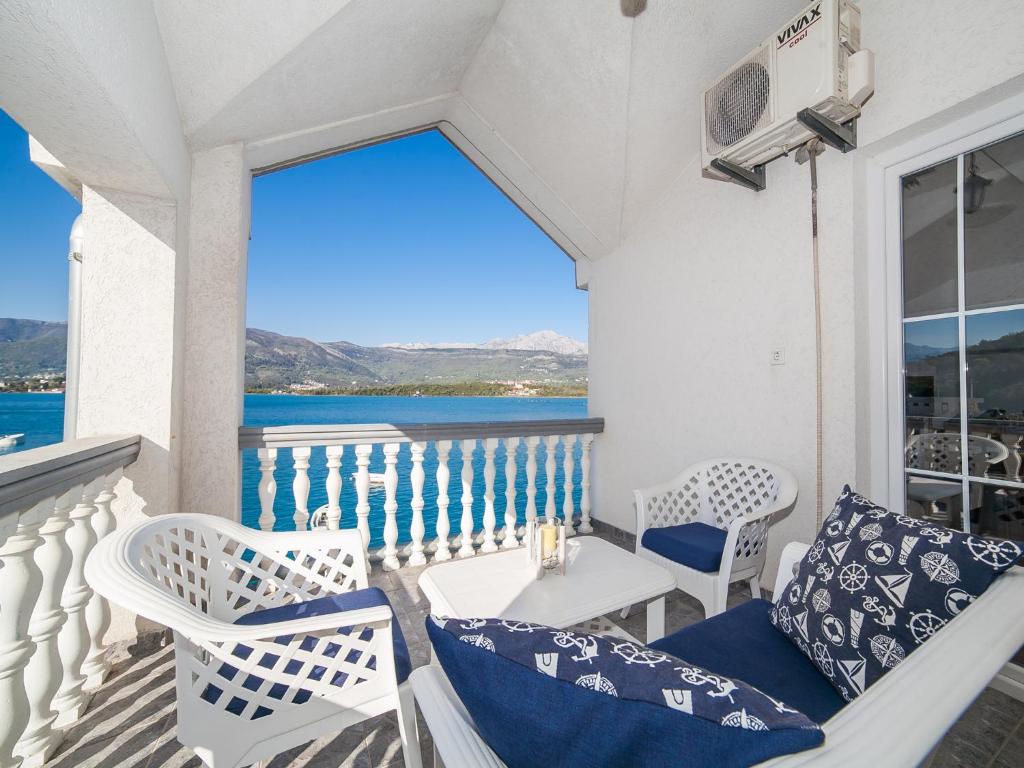 einen Balkon mit einem Tisch und Stühlen sowie Meerblick in der Unterkunft Apartments Elena in Tivat